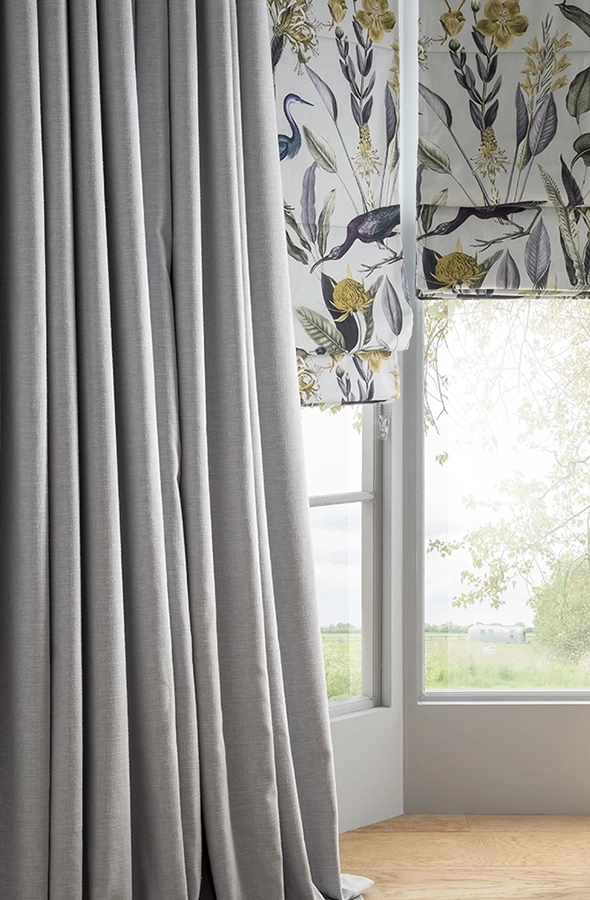 Room with animal design roman blind and plain grey curtain from Graham & Brown